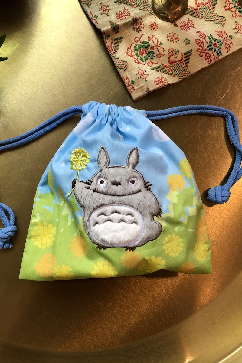 Totoro-säilytyspussi kukkaniityllä